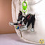 A custom die-cut acrylic keychain featuring a black and white Boston Terrier dog playing with a blue and yellow ball, attached to a bright green key clasp. The keychain is shown hanging next to a white textured fabric bag.
