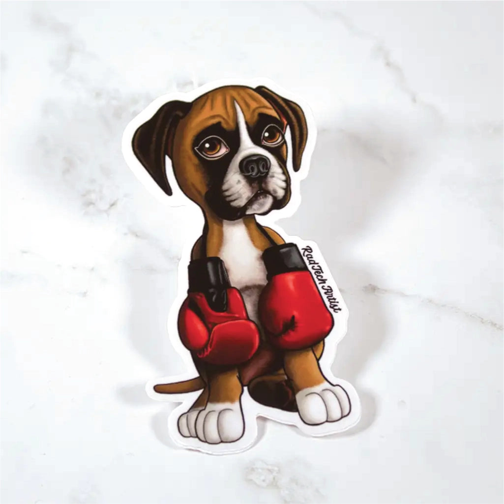 Sticker of a fawn boxer puppy wearing red boxing gloves on a marble surface
