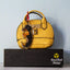 Acrylic Dachshund keychain with epoxy finish, featuring a black-and-tan dog hugging a hot dog with mustard. Attached with a bright red lobster clasp to a textured yellow mini purse with gold lock hardware, displayed on a black box with the Rad Tech Artist logo.
