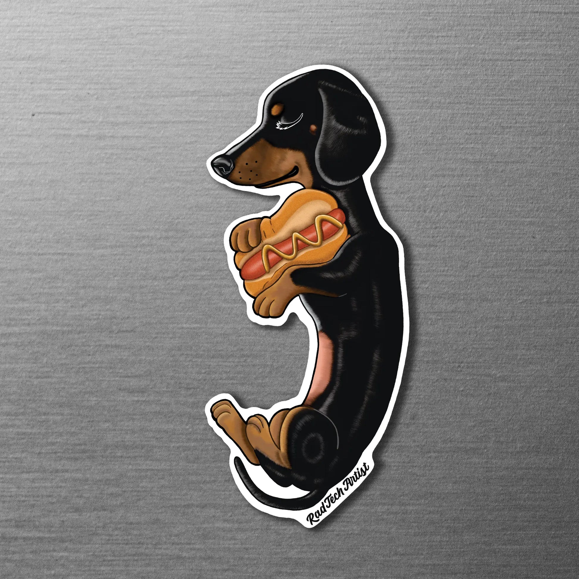 Magnet of a black and tan dachshund with a hot dog on a metallic surface