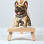 sticker of a fawn French Bulldog design on a small wooden easel against a light background