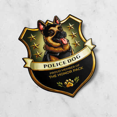 A shield-shaped badge or sticker featuring an illustrated German Shepherd police dog with the text 'POLICE DOG' and 'PROUD MEMBER OF THE HONOR PACK' on a black, gold, and olive background, shown on a light marble surface.