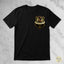 A black short-sleeve crewneck t-shirt featuring a German Shepherd police dog crest graphic on the left chest, laid flat on a light gray marble-textured background.