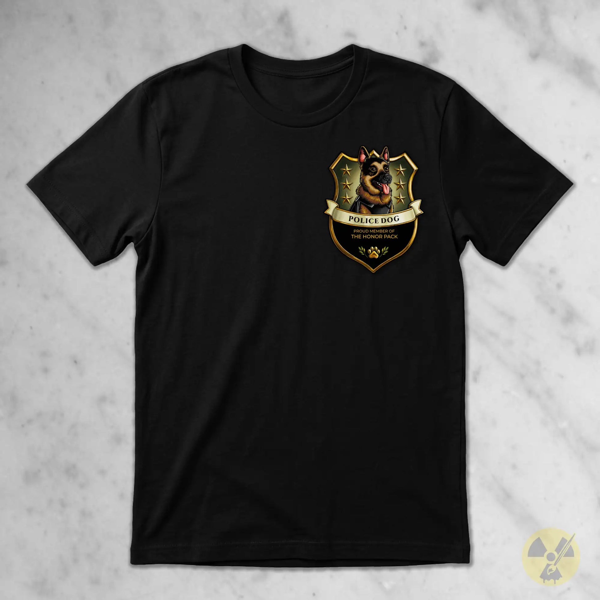 A black short-sleeve crewneck t-shirt featuring a German Shepherd police dog crest graphic on the left chest, laid flat on a light gray marble-textured background.