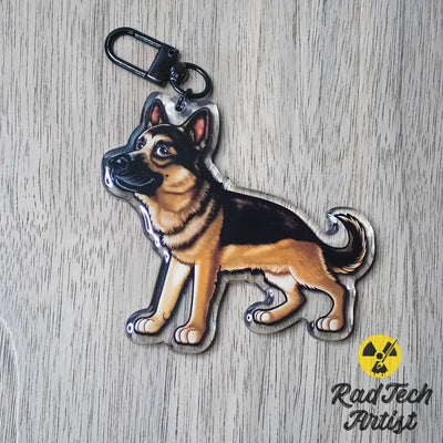 German Shepherd dog keychain featuring a black and tan standing pose, photographed on a neutral surface.