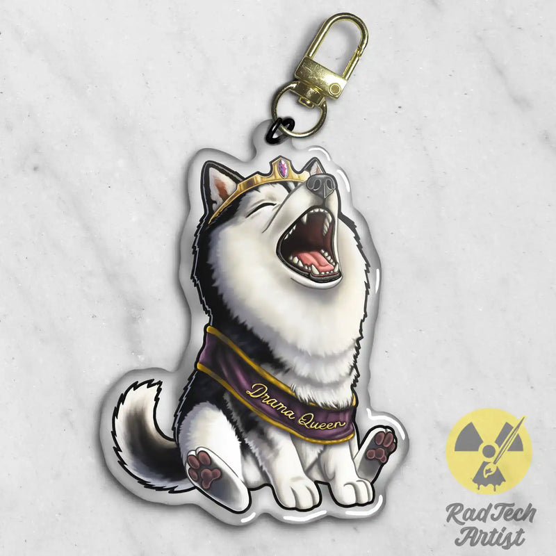 Keychain with a black and white husky dog design wearing a tiara and a sash that says 'drama queen' written on it. 