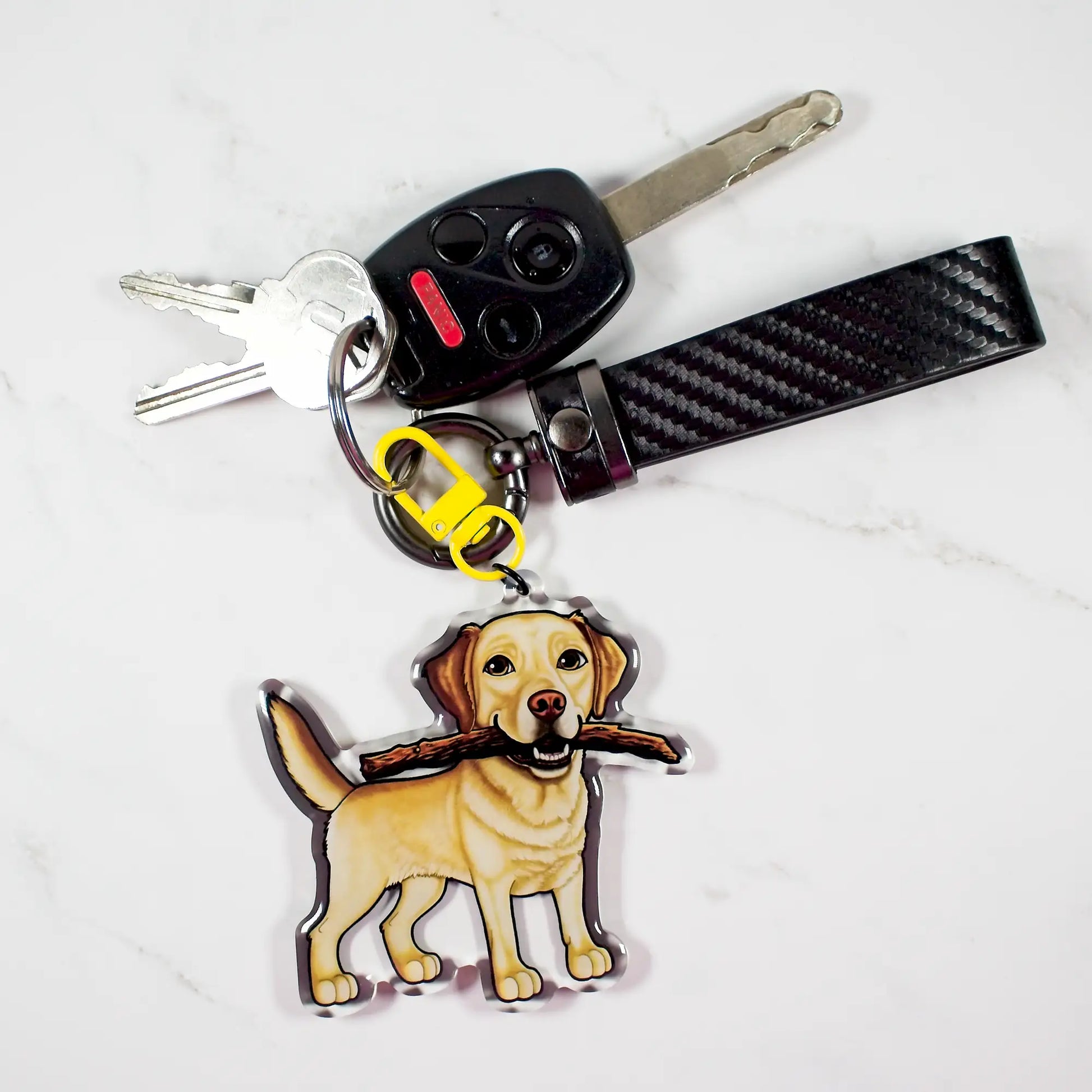 Keychain with a yellow Labrador Retriever dog design and carbon fiber pattern on a white background