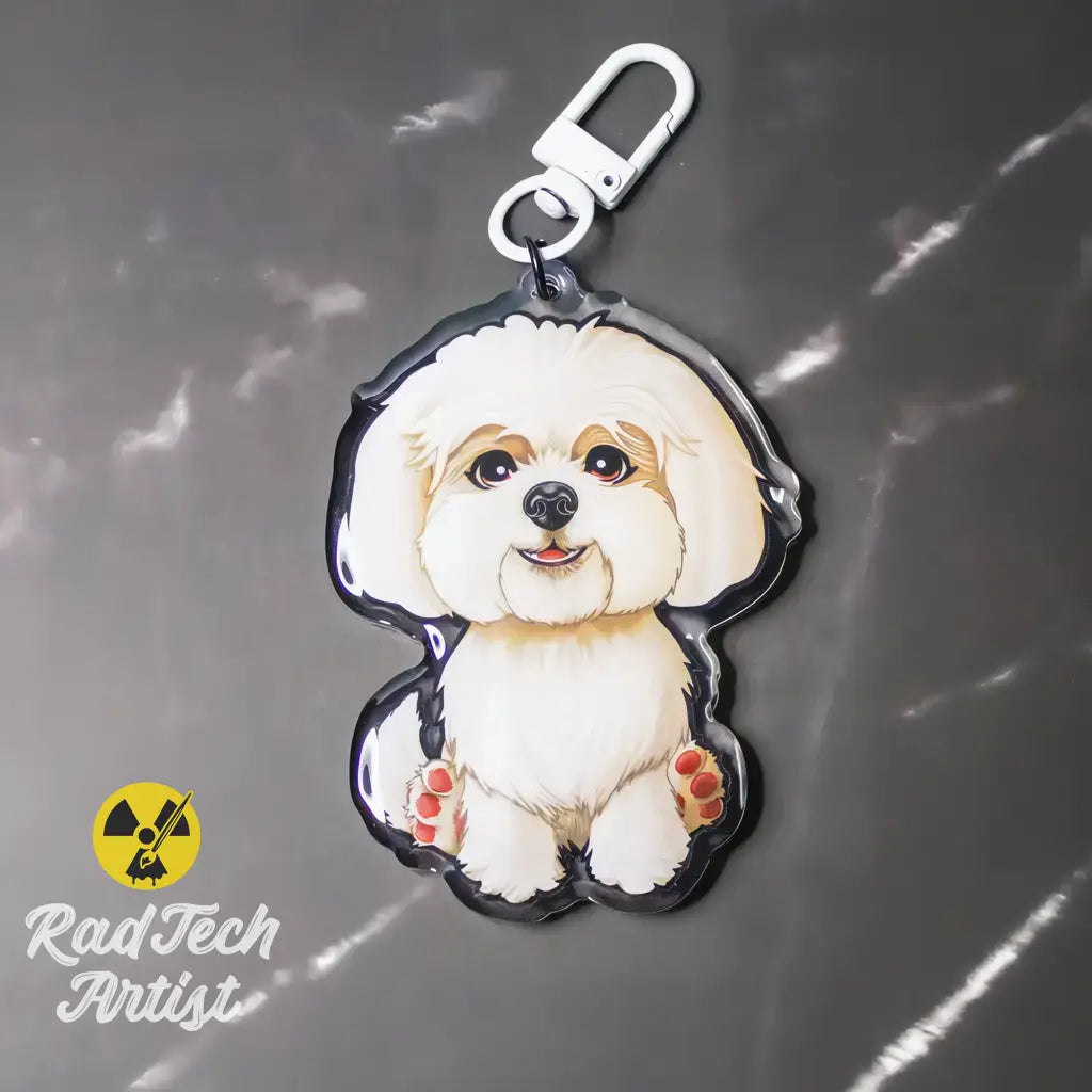 Maltese acrylic dog keychain photographed on a gray background, featuring a white coat illustration and silver lobster clasp.