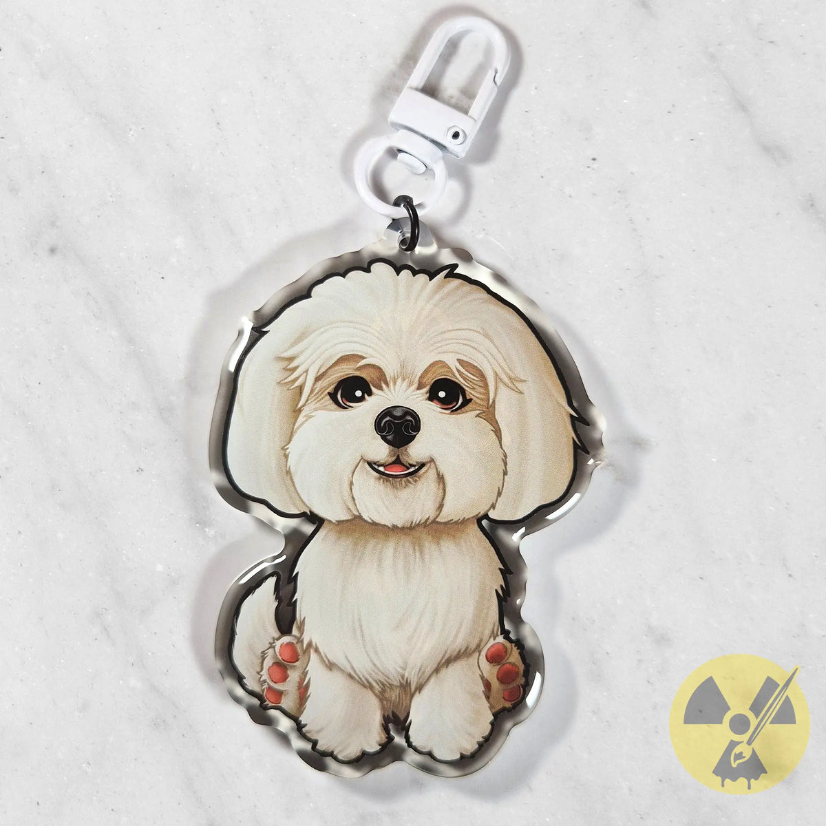 A custom acrylic pet keychain shaped like a fluffy white Maltese dog, featuring a white metal clasp at the top, displayed on a light gray marble surface.