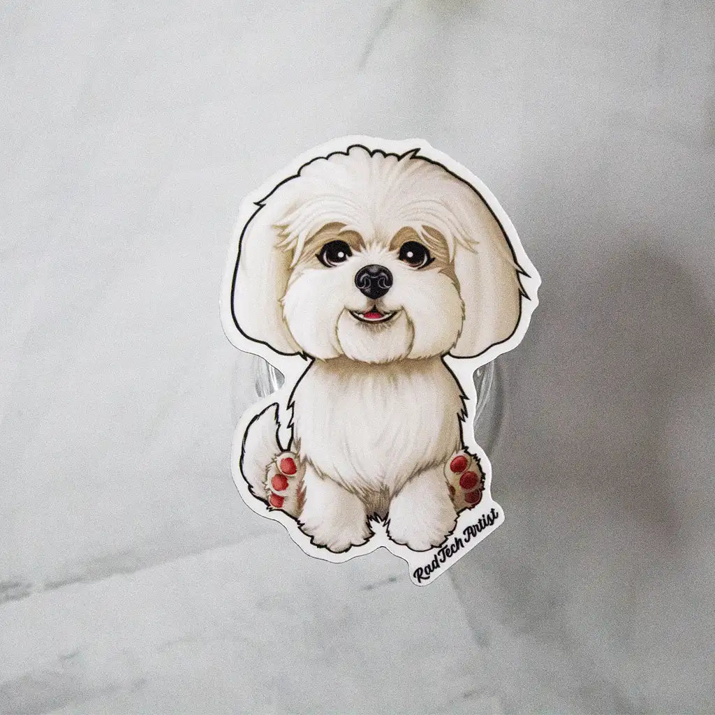 White Maltese dog magnet with fluffy coat displayed on a glass stand against a marble background.