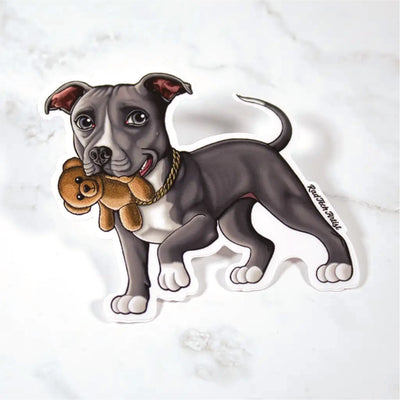Sticker of a blue and white Pit Bull holding a teddy bear on a marble surface