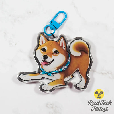 red Shiba Inu keychain with a blue strap on a light gray background