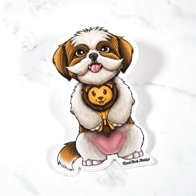 Sticker of a gold and white Shih Tzu with a lion plush toy on a marble surface