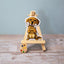 Vinyl dog sticker of a Golden Retriever puppy holding a bone on a mini wooden easel – waterproof Golden Retriever sticker for dog lovers.