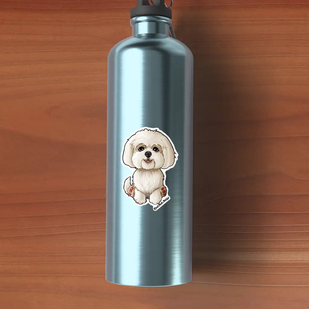 Mock-up of a white Maltese dog vinyl sticker placed on a metallic blue water bottle, resting on a wooden surface. The fluffy pup is sitting with pink paw pads showing and a sweet, friendly smile.