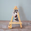 Vinyl dog sticker of a salt and pepper Miniature Schnauzer with a red bandana on a mini wooden easel – waterproof Schnauzer sticker for dog lovers.
