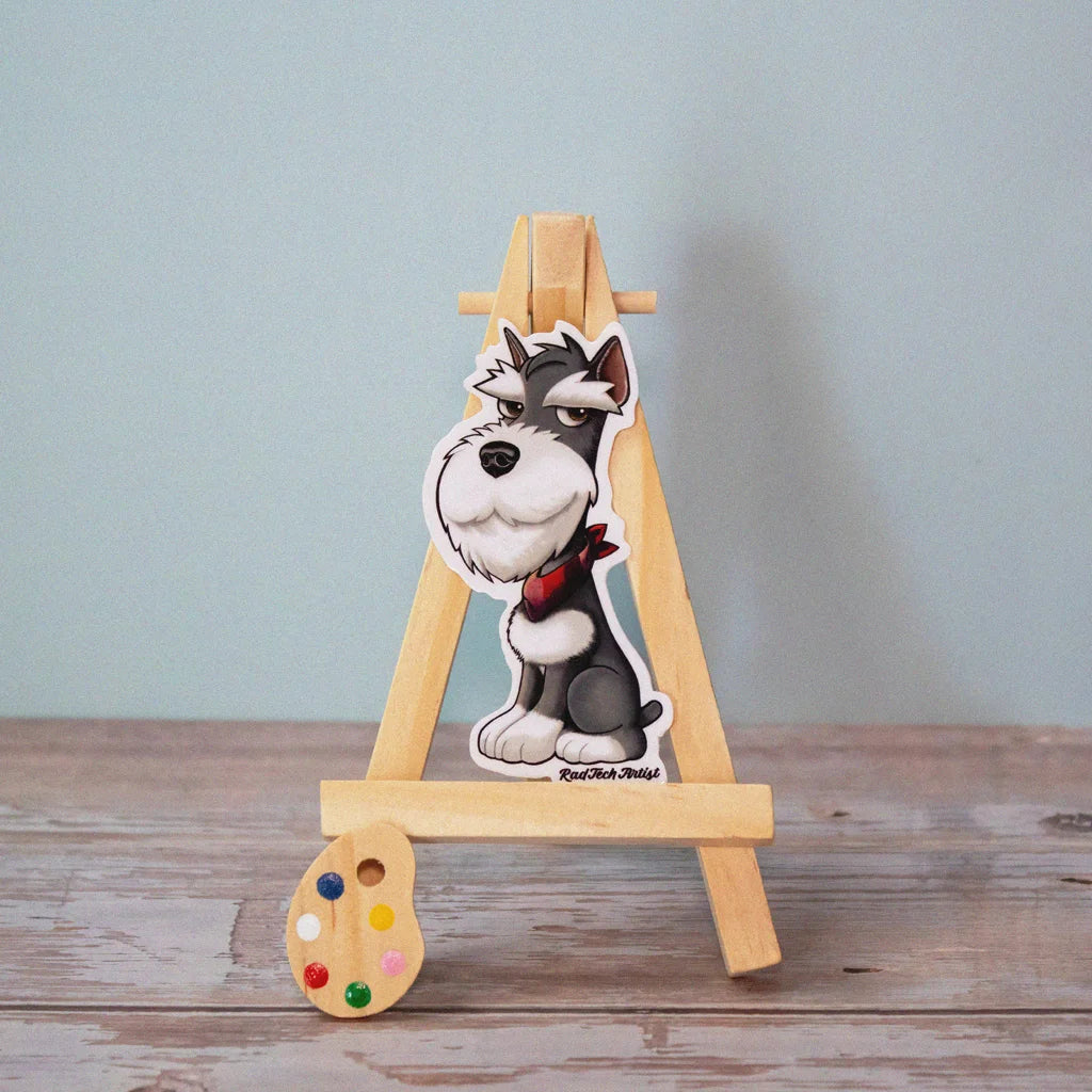 Vinyl dog sticker of a salt and pepper Miniature Schnauzer with a red bandana on a mini wooden easel – waterproof Schnauzer sticker for dog lovers.